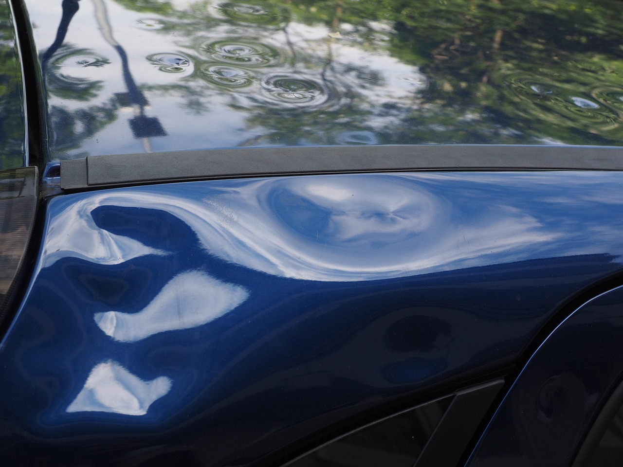close-up of hail damage on a blue car